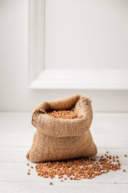 Beyaz arka plan üzerinde ham karabuğday ile küçük bir keten çuval. Geleneksel Rus mutfağı. Sağlıklı bir diyet kavramı.