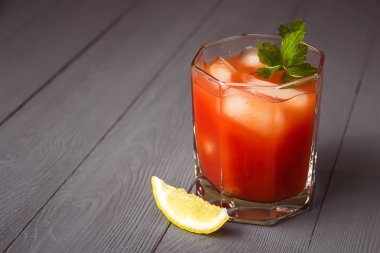 Copyspace ile gri ahşap masa üzerinde gözlük buz ile Kokteyl Bloody Mary.