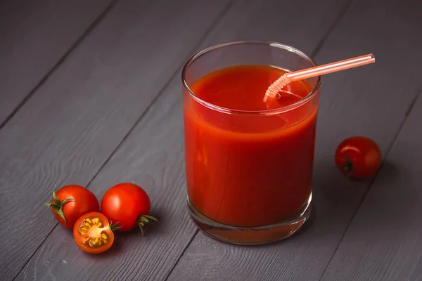 Tomato juice in glasses on gray wooden table. — Stock Photo, Image