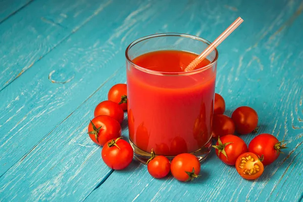 Jugo de tomate en vasos sobre mesa de madera azul . — Foto de Stock