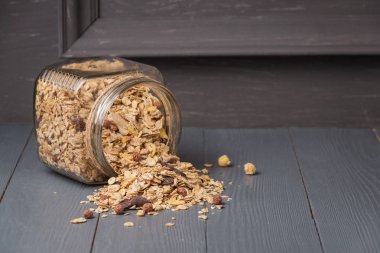 granola, kurutulmuş meyve ve fındık en sağlıklı tohum ile gri ahşap masada boşaltmak ile biyo.