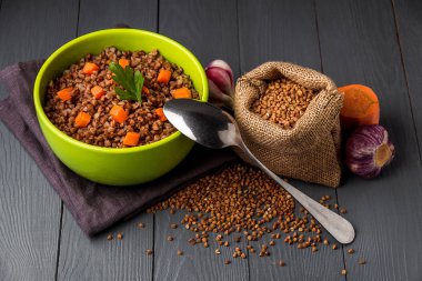 Gri ahşap masa üzerinde lezzetli karabuğday lapası Yeşil kase.