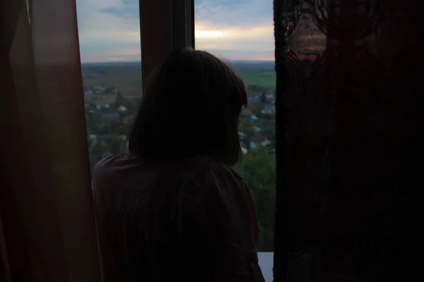 Kız pencereden dışarı bakıyor.