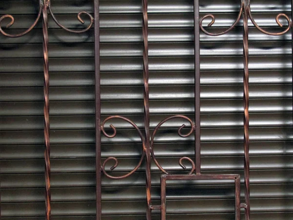 Iron gray blinds behind bars. photo — Stock Photo, Image
