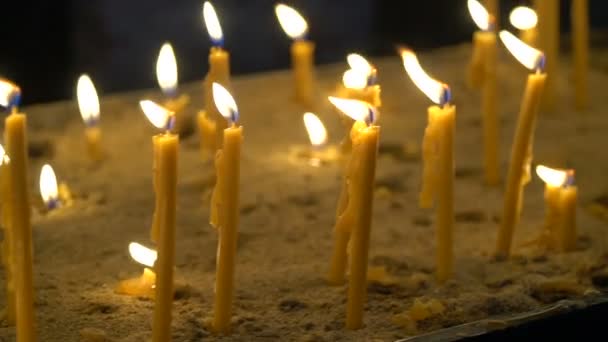 Vue sur les nombreuses bougies ortodoxes de l'église qui brûlent dans le temple. Gros plan — Video