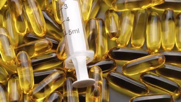 Pillen en capsules met een spuit bovenop, draaiend in een cirkel — Stockvideo
