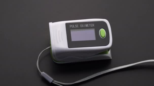 Oxímetro de pulso con jeringa. Monitor que muestra saturación de oxígeno en la sangre y pulso del paciente. De cerca. — Vídeo de stock