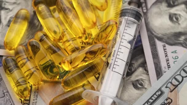 Píldoras, ampollas y jeringas que giran en dinero concepto de costo de atención médica. Primer plano — Vídeo de stock