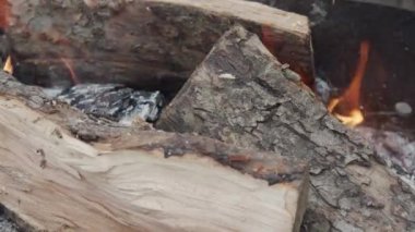 Turuncu alevdeki tahta kütükler. Yanan odunlar. Yanmış odunların üzerindeki kırmızı dillerin hareketi. Yakın plan..