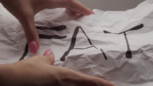 Mãos amassam uma folha de papel com a gordura de inscrição — Vídeo de Stock