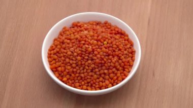 Kırmızı mercimek ahşap arka planda kasede dönüyor. ProRes 422