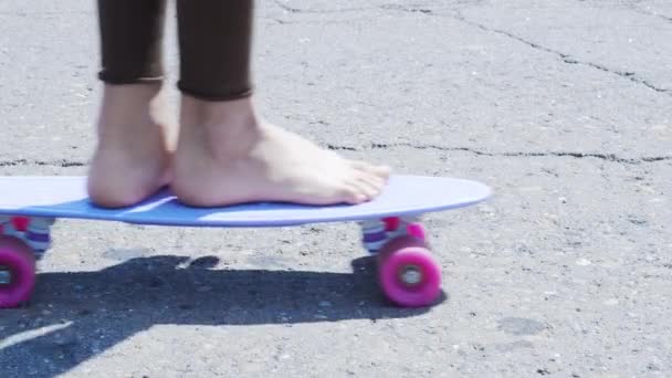 アスファルトの道路に自分自身を押してスケートボードに乗る女の子。ProRes 422 — ストック動画