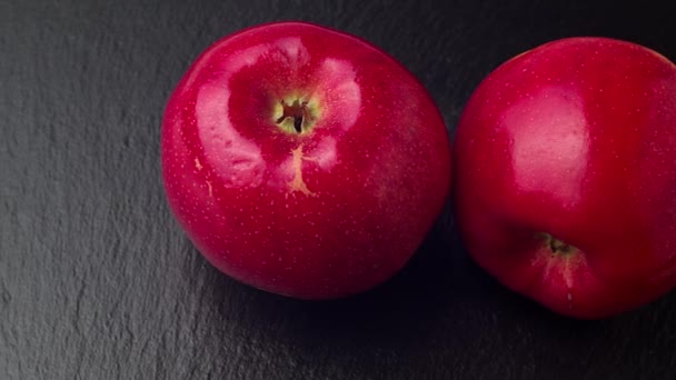 Deliciosas manzanas rojas se amontonan en el tablero de piedra negra en movimiento. 4K ProRes 422 — Vídeo de stock