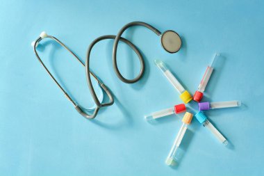 Phonendoscope stetoskop, mavi arka planda vakum test tüpleri.