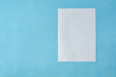 Açık mavi arka planda izole edilen Beyaz sac kağıt.