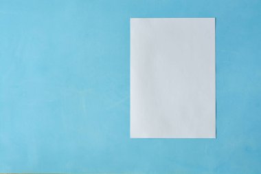 Açık mavi arka planda izole edilen Beyaz sac kağıt.