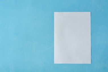 Açık mavi arka planda izole edilen Beyaz sac kağıt.