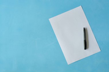Açık mavi arka planda siyah kalem ısoleted beyaz levha kağıt.