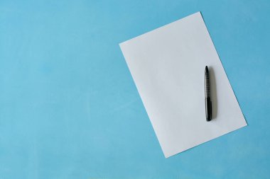 Açık mavi arka planda siyah kalem ısoleted beyaz levha kağıt.