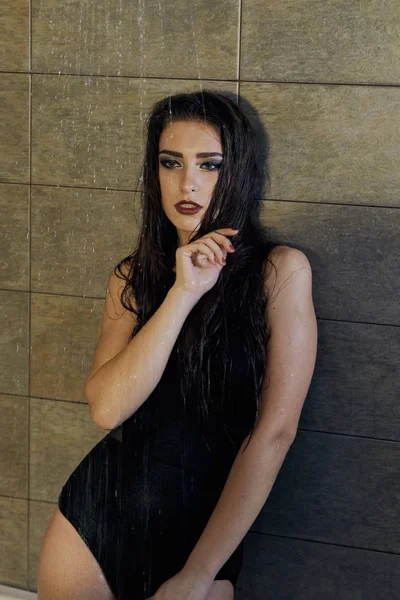 Menina em uma roupa de banho preta tomando um banho para design de conceito . — Fotografia de Stock