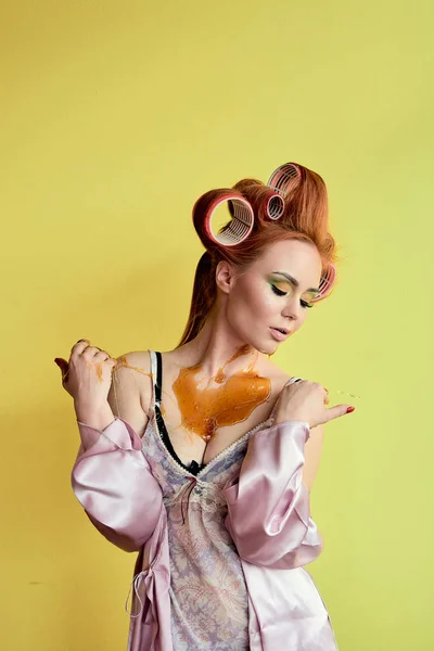 Young redhead woman with shugaring paste on her hands, face, body and chest.