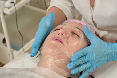 Güzellik salonunda soyma ve yüz temizleme prosedürü yapan genç kadın.