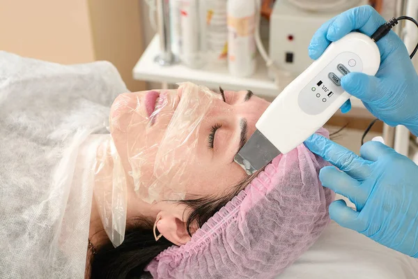 Jonge vrouw in schoonheid salon doen peeling en gezichtsreiniging procedure. — Stockfoto