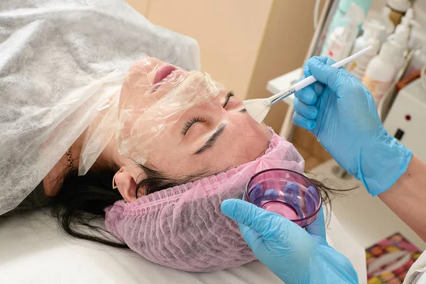 Jonge vrouw in schoonheid salon doen peeling en gezichtsreiniging procedure. — Stockfoto
