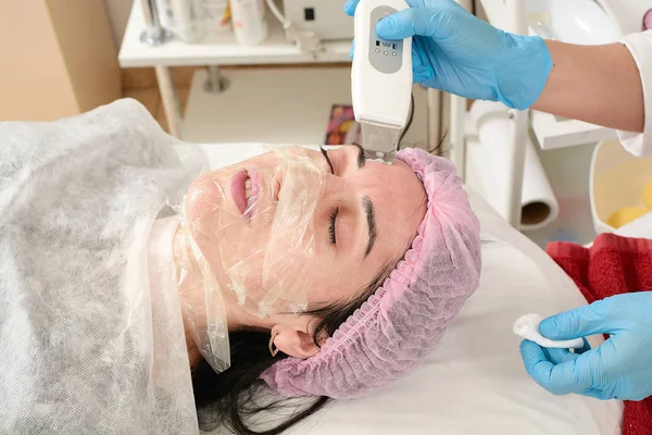 Jonge vrouw in schoonheidssalon doen echografie peeling en gezichtsreiniging procedure. — Stockfoto