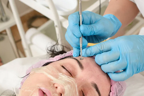 Jonge vrouw in schoonheidssalon heeft handmatige face Cleaning. — Stockfoto