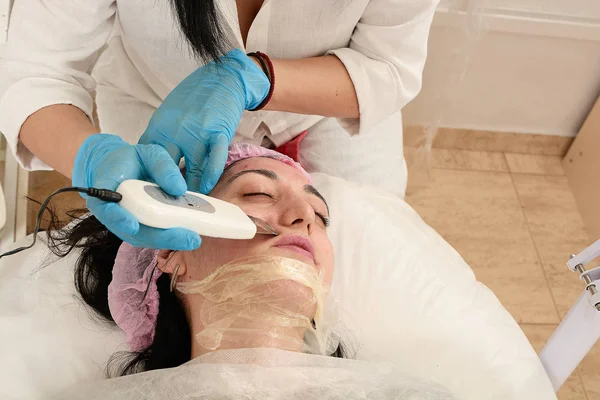 Młoda kobieta w salonie piękności robi peeling ultradźwiękowy i zabieg oczyszczania twarzy. — Zdjęcie stockowe