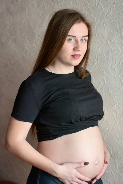 Fiatal terhes nő. Terhes, gyönyörű nő pózol otthon.. — Stock Fotó