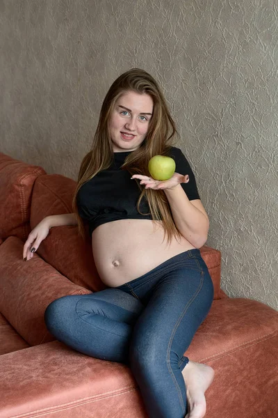 Young pregnant woman. Pregnant beautiful woman with green apple posing at home. Happy pregnancy. — 스톡 사진