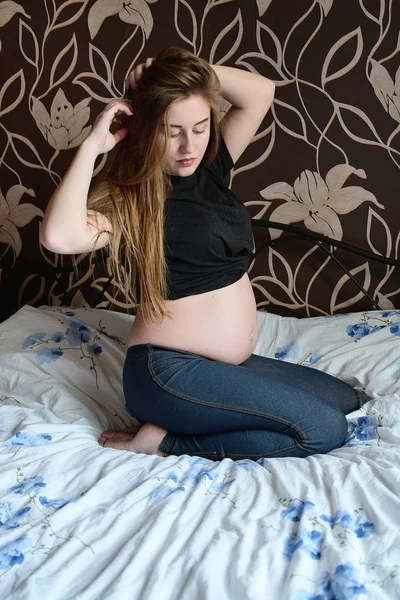 Jeune femme enceinte. Belle femme enceinte posant à la maison. Bonne grossesse . — Photo