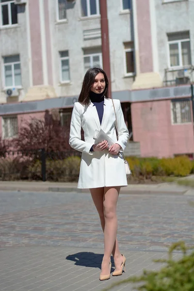 Elinde bir gazete ile bir şehir sokakta zarif genç kadın.