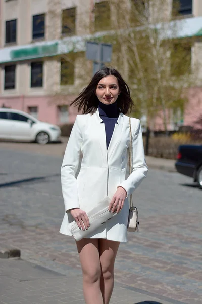 Elinde bir gazete ile bir şehir sokakta zarif genç kadın.