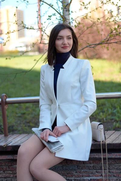 Jovem elegante posando em uma rua da cidade com um jornal e celular em suas mãos . — Fotografia de Stock