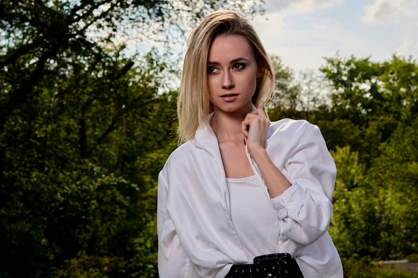 Blonde woman in the old sunny summer city park. Young woman modern portrait. — Stock Photo, Image