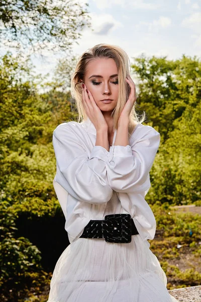 Blond kvinna i den gamla soliga sommar stadsparken. Ung kvinna modernt porträtt. — Stockfoto