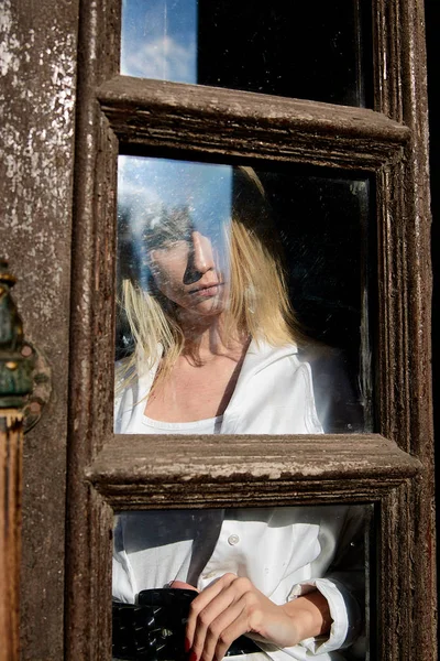 Mujer rubia de pie en la vieja puerta de madera. La vieja puerta de madera. Mujer joven retrato moderno . — Foto de Stock