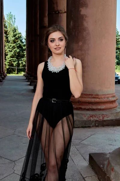 Mujer joven está usando un vestido negro transparente sexy. Mujer joven retrato moderno . — Foto de Stock