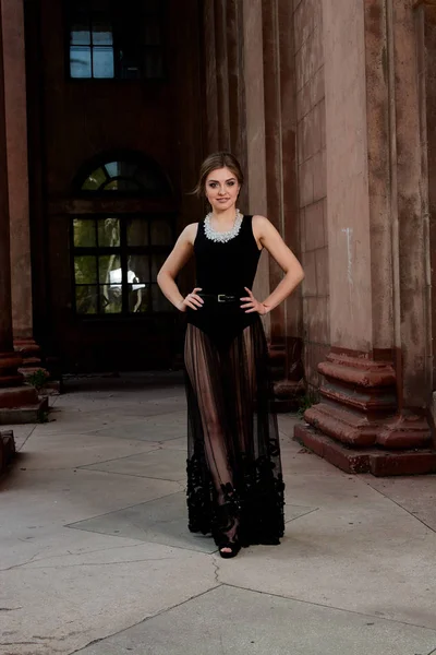 Mujer joven está usando un vestido negro transparente sexy. Mujer joven retrato moderno . — Foto de Stock