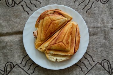 Sıcak Çıtır Sandviç. Kahvaltı için beyaz tabakta taze, çıtır çıtır, lezzetli tost makinesi. Kahvaltı için yemek. Vejetaryen yemeği..