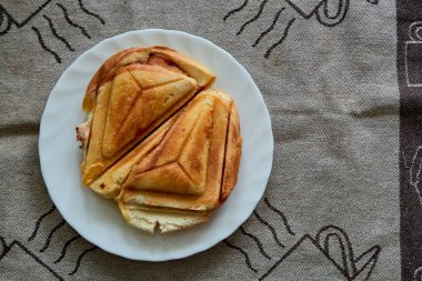 Sıcak Çıtır Sandviç. Kahvaltı için beyaz tabakta taze, çıtır çıtır, lezzetli tost makinesi. Kahvaltı için yemek. Vejetaryen yemeği..
