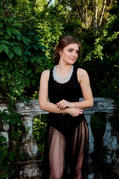 Young attractive woman in the sexy transparent black dress. Young woman portrait.