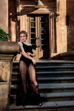 Seksi şeffaf siyah elbiseli çekici bir kadın. Genç kadın portresi.