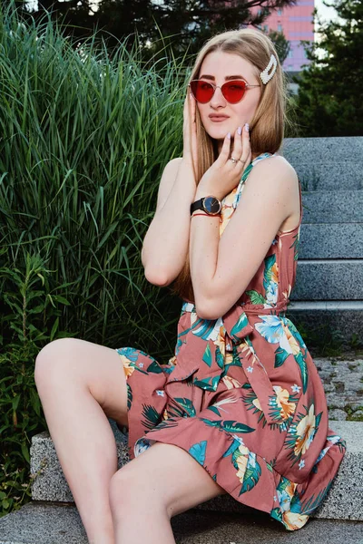 Jovem mulher atraente. Óculos de sol vermelhos, vestido a cores. Retrato de mulher jovem . — Fotografia de Stock