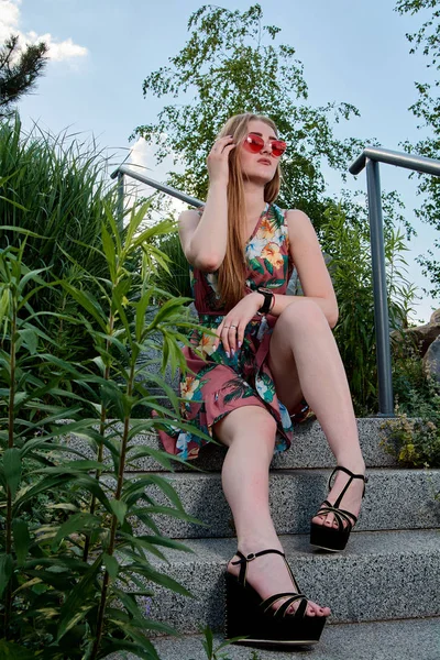 Jovem mulher atraente. Óculos de sol vermelhos, vestido a cores. Retrato de menina . — Fotografia de Stock