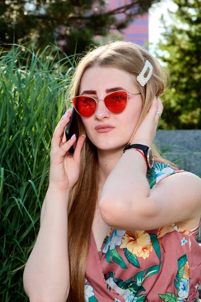 年轻迷人的女人红色太阳镜，彩色连衣裙，手机，5g，4g，3g，2g，Lte网络. — 图库照片