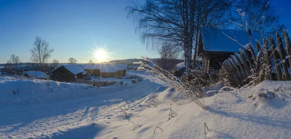 Kırsal manzara kış - karla kaplı köy evleri Güneş yaktı. Arkhangelsk region, Rusya Federasyonu. Panorama.